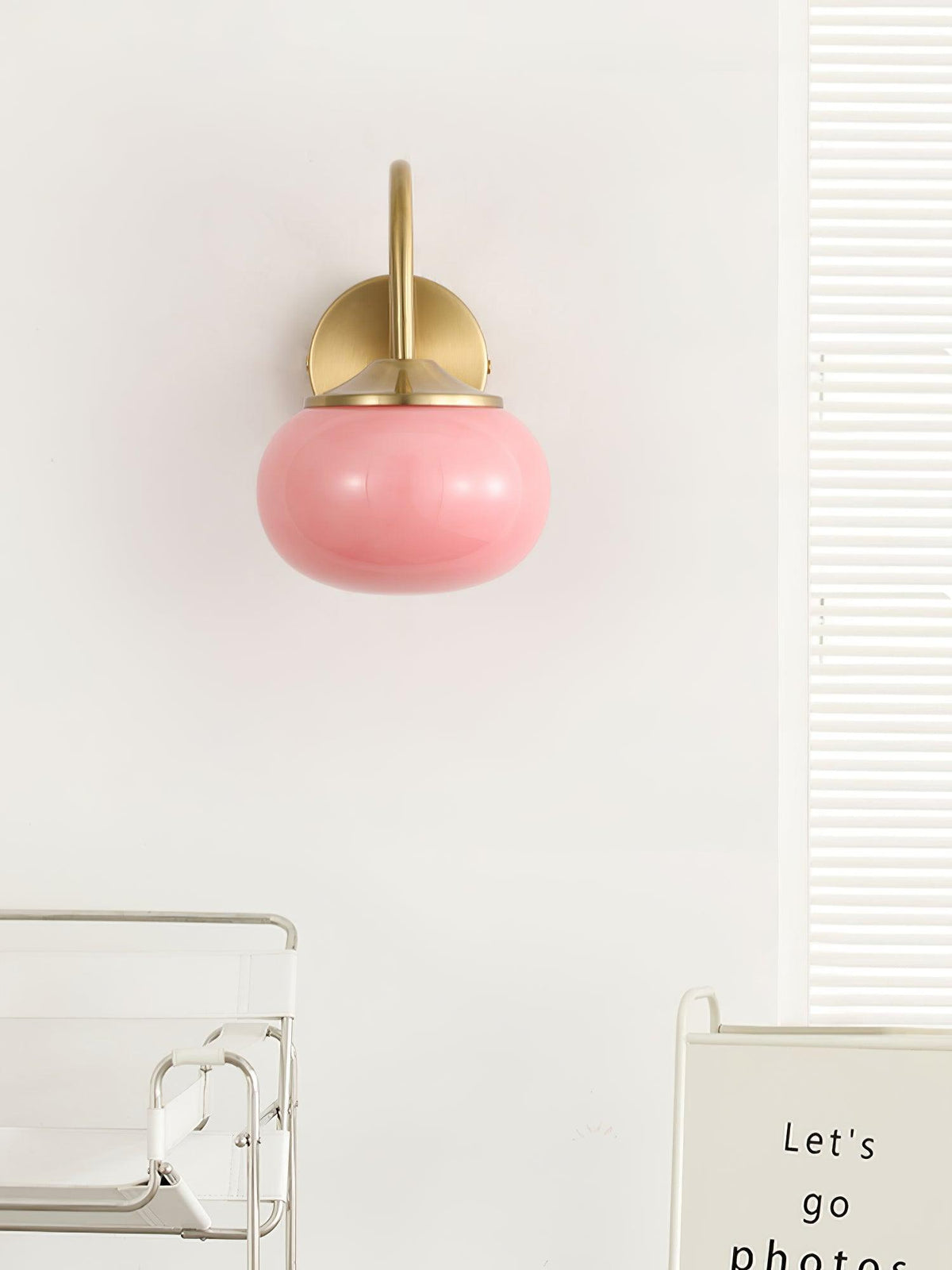 A glass shelf unit sits below this Clérachic wall light in copper and pink glass, mounted on a plain white wall.