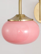 Close view of the pink glass shade on this Clérachic wall light, showing its rounded, bulbous form.