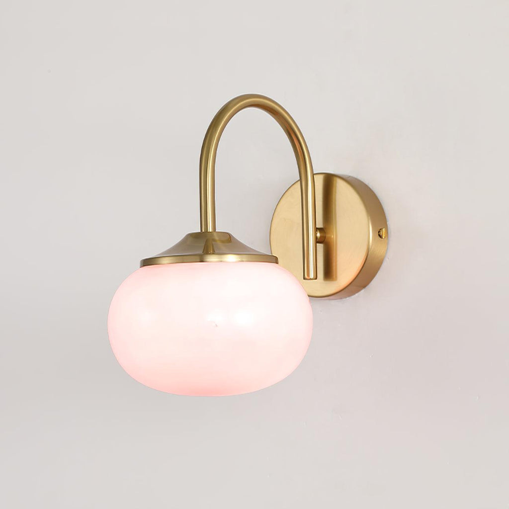 A pink glass shade catches the light on this Clérachic wall light in copper, unlit, on a plain white wall.