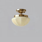 Glass-shade ceiling light glowing warm above a small room