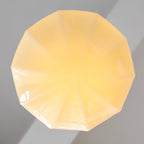 Compact Art Deco pendant light shown lit close to the ceiling