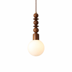 Ash wood pendant light with walnut hardware glowing softly