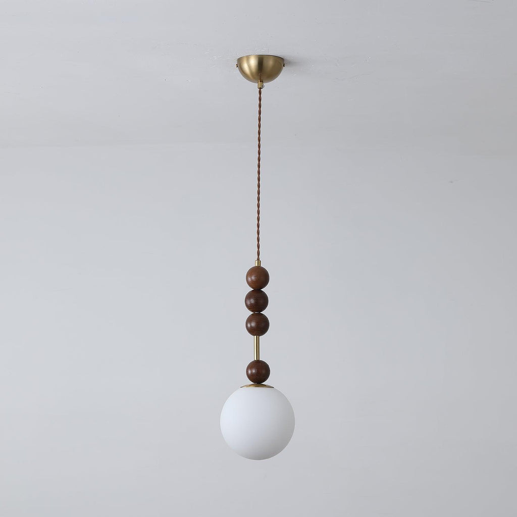 Ash wood bead pendant light glowing over an interior setting