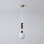 Ash wood bead pendant light glowing over an interior setting