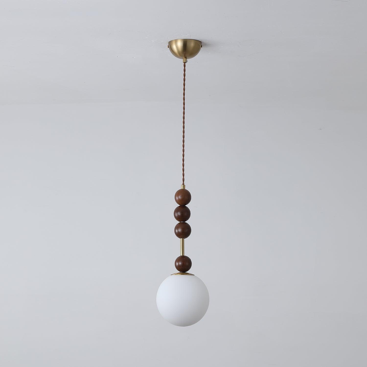 Ash wood bead pendant light glowing over an interior setting
