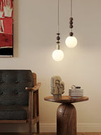Wood-bead pendant light hanging beside a neutral wall