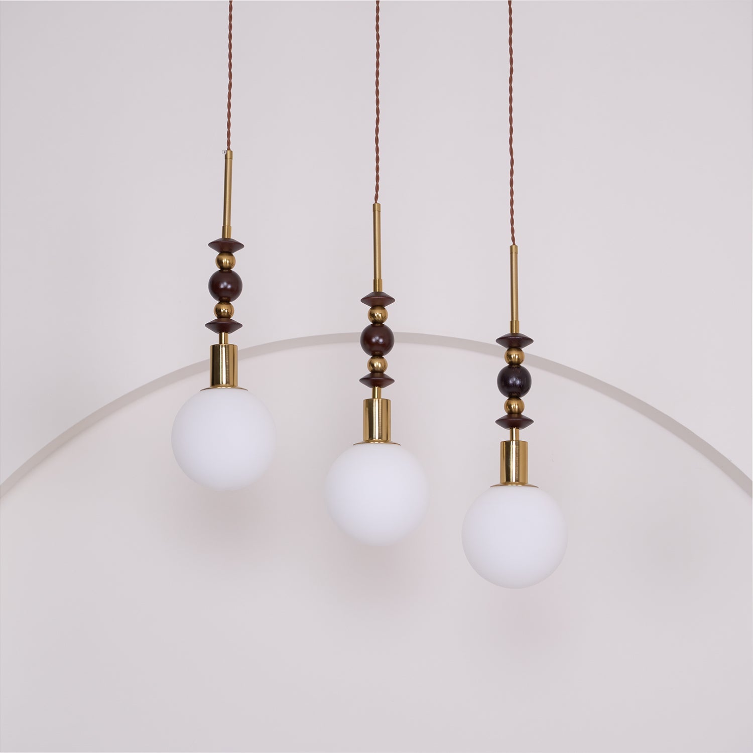 Ash wood pendant light shown lit above a styled space