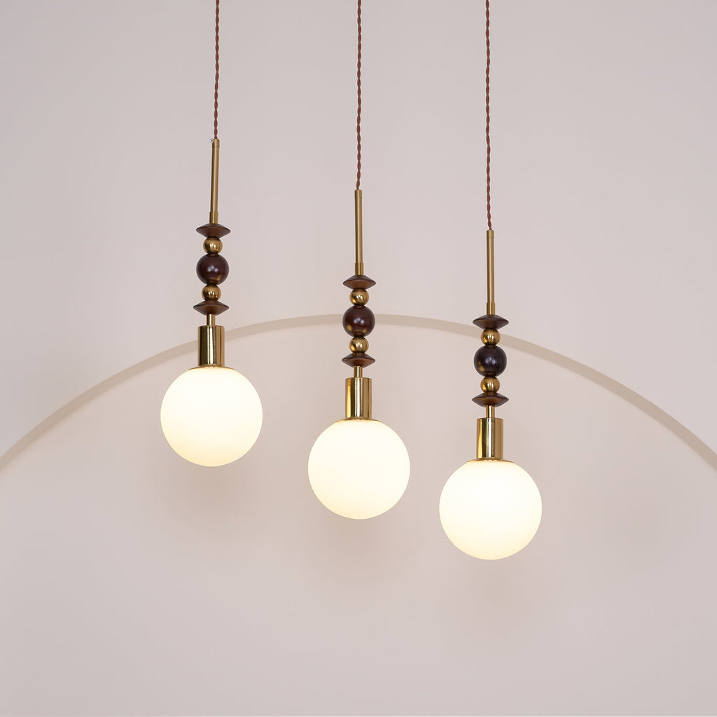 Pendant light with strung ash wood beads and glass shade