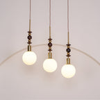 Pendant light with strung ash wood beads and glass shade