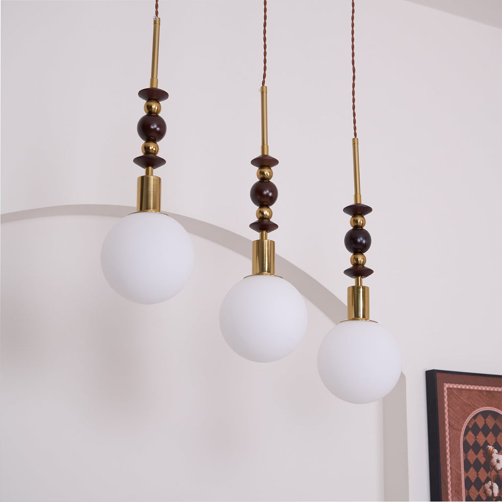 Wood-bead pendant light detail with warm metallic hardware