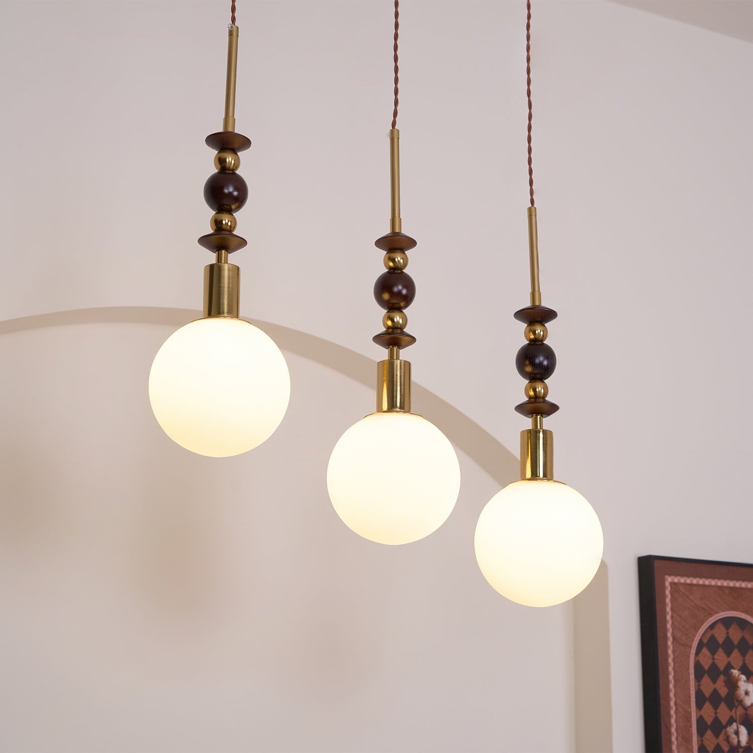Wood-bead pendant light with white glass shade, lit warm
