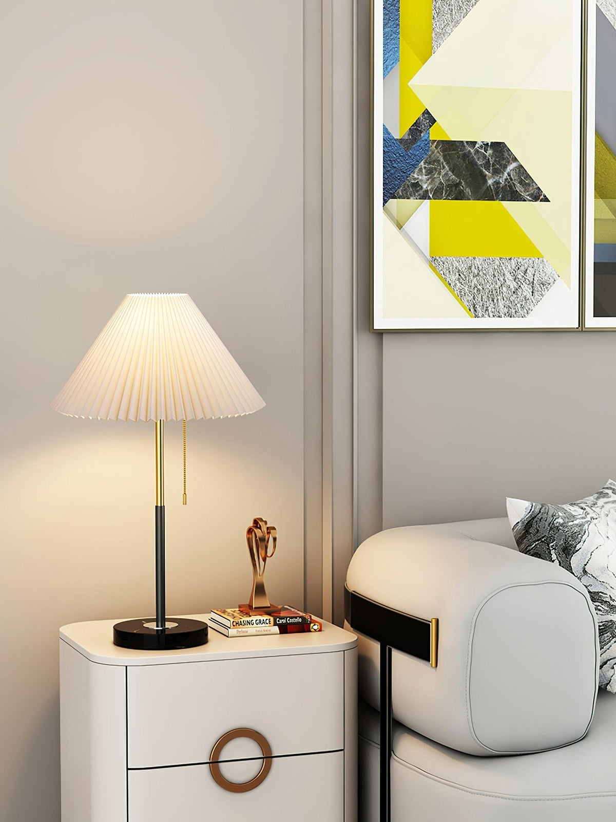 Clérachic lamp lit beside framed geometric art, its cream pleated shade glowing on the bedside cabinet.
