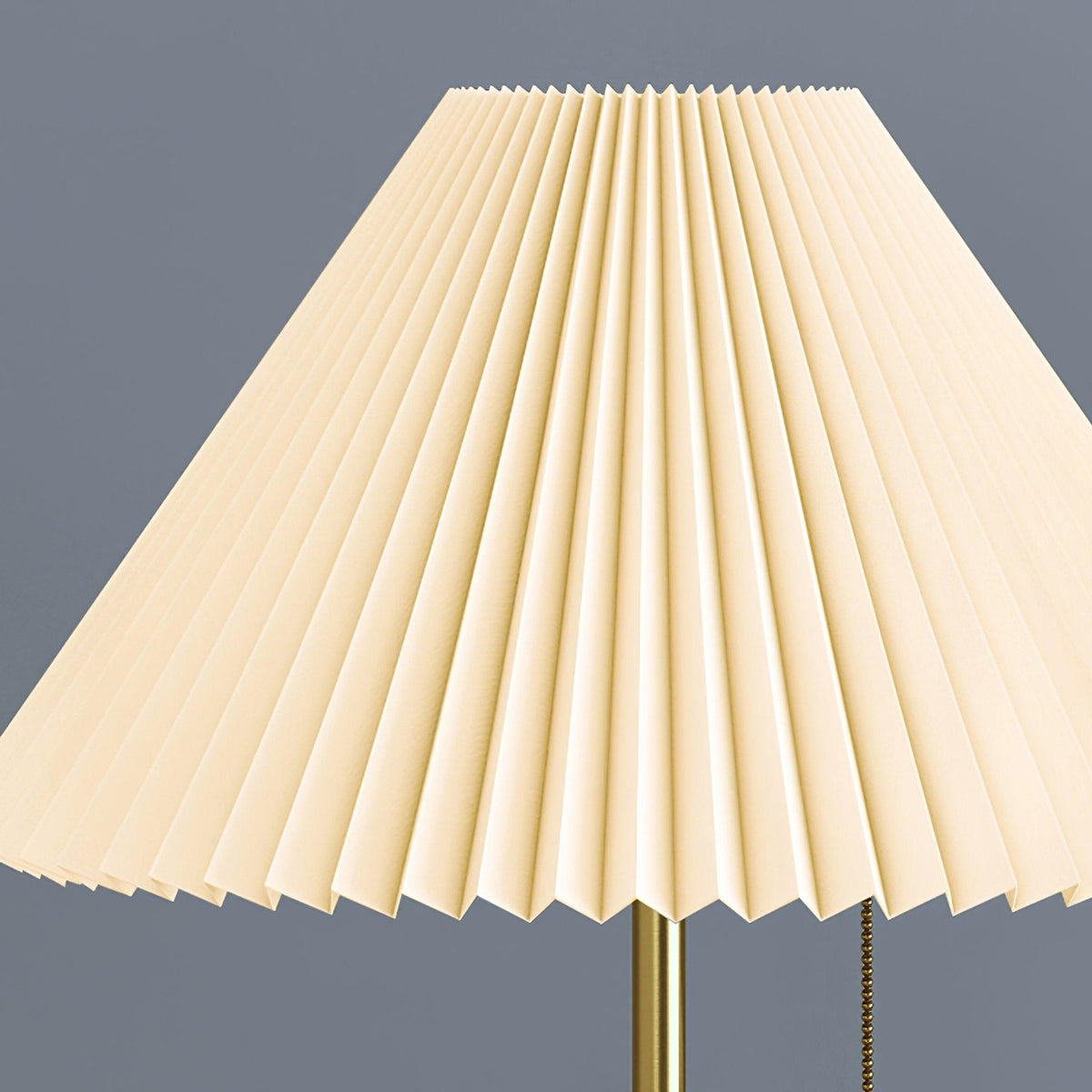 Close-up from below of the Clérachic lamp's pleated fabric shade, showing its fan-folded texture and brass finial.