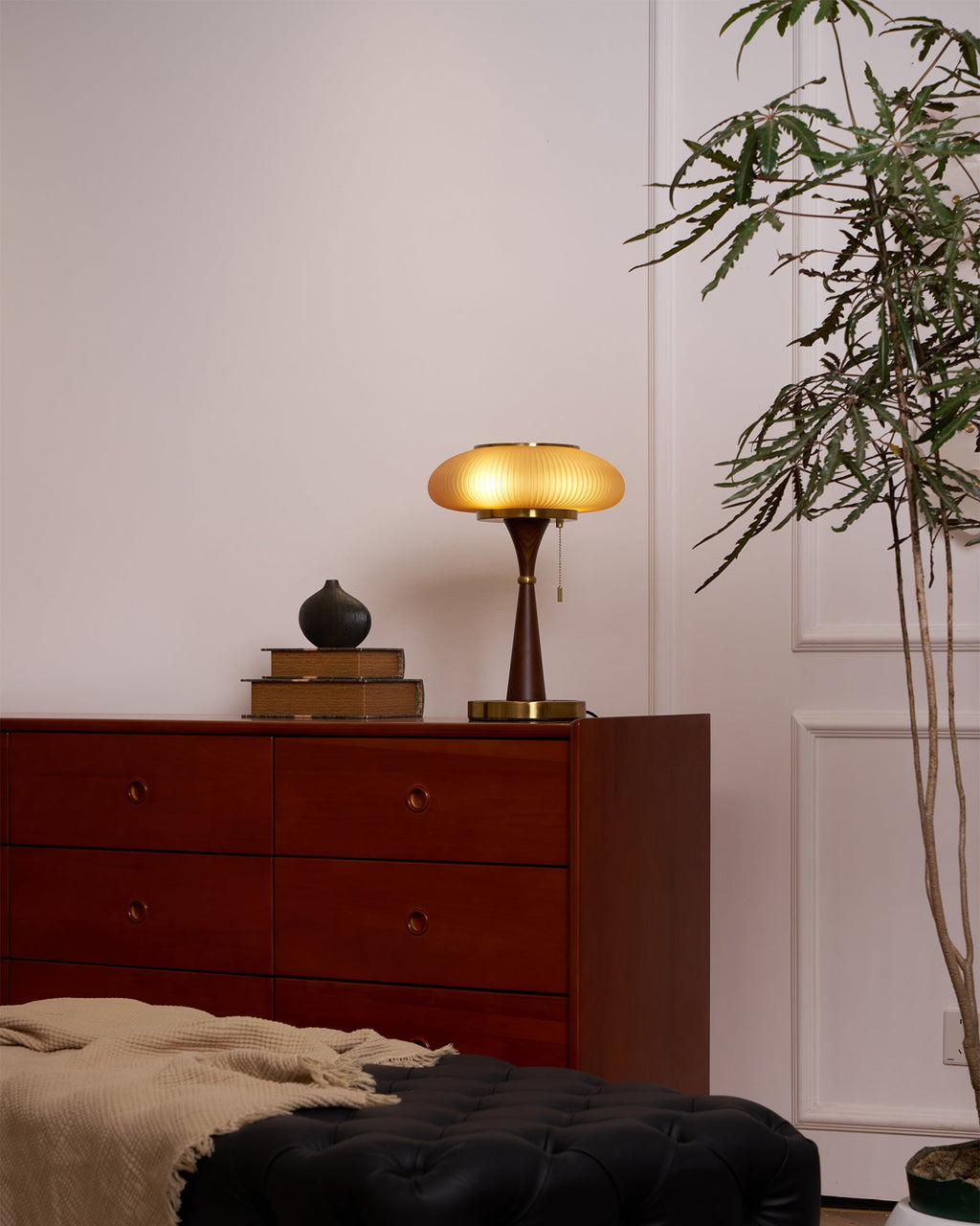 Table lamp with textured glass cap casting a warm amber glow