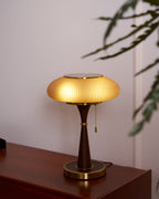 Matsutake table lamp with amber glass shade beside a chair