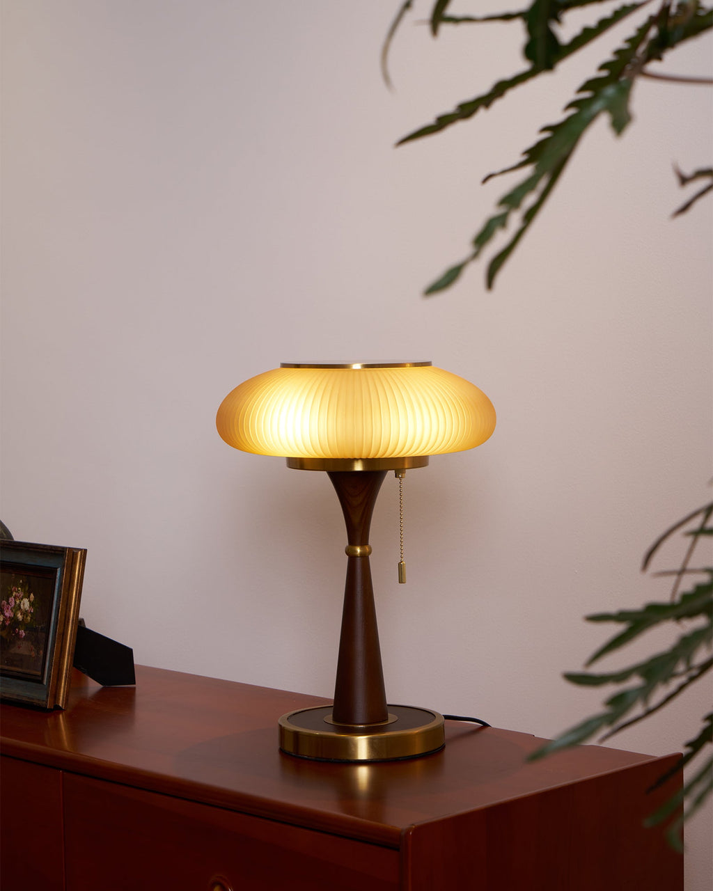 Mushroom glass table lamp glowing amber in a dim interior