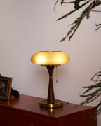Mushroom glass table lamp glowing amber in a dim interior