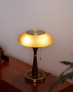 Table lamp with glass shade and metal base in a cosy room
