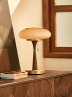 Glass-shade table lamp with curved base casting soft light