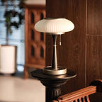 Matsutake table lamp lit warm in a quiet reading nook