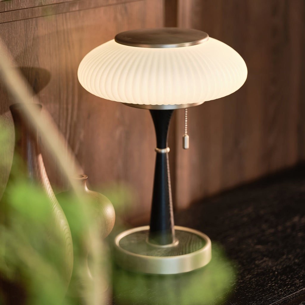 Mushroom-cap table lamp with warm glow on a wooden surface