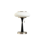 Mushroom glass table lamp with metal base on a side table