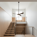 Ceiling fan light shown from the side with wood blades and shade