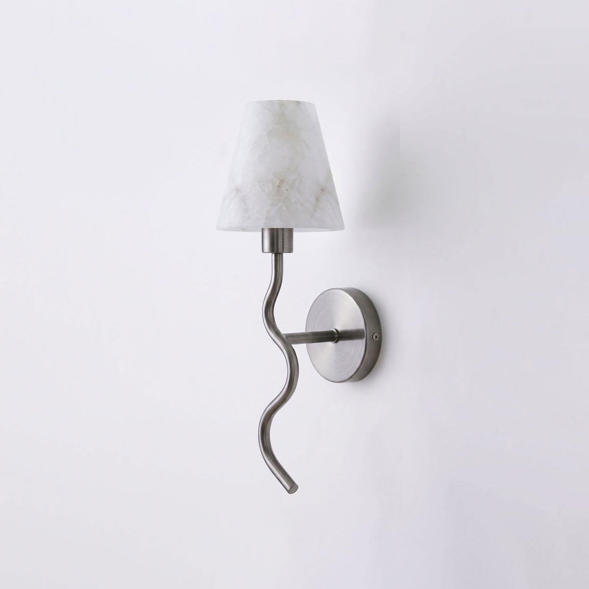Centred on a plain backdrop, this Clérachic wall sconce's brushed nickel serpentine arm curls beneath a white cone shade, unlit.