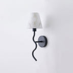 Angled on a plain backdrop, this Clérachic wall sconce shows its matte black finish, serpentine arm and white cone shade, unlit.