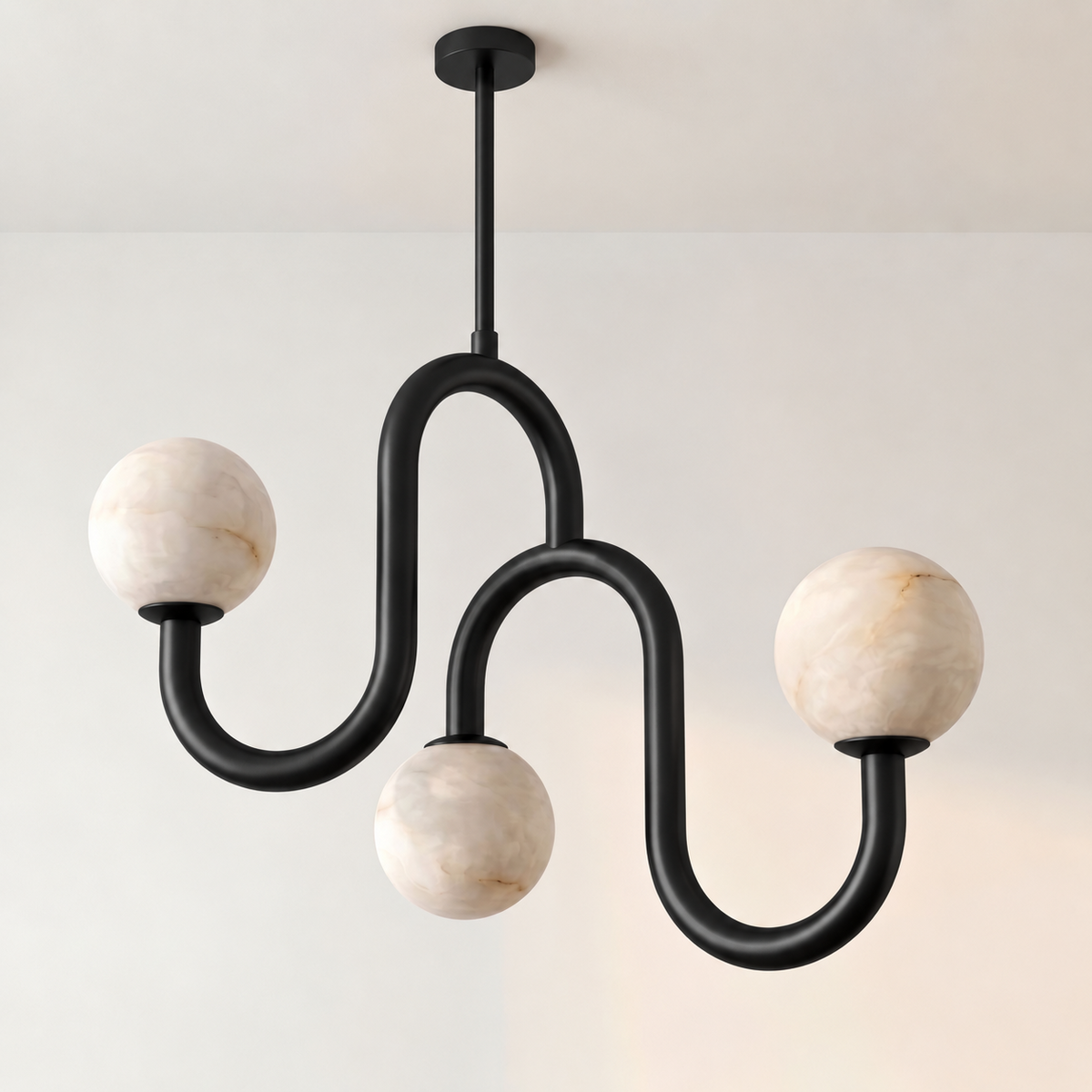 Photographed close on white, this Clérachic chandelier's black finish traces a looping tube down to three alabaster globes.
