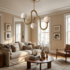 In a sunlit living room with a beige sofa and framed prints, this Clérachic chandelier's brass finish glows above the seating area.