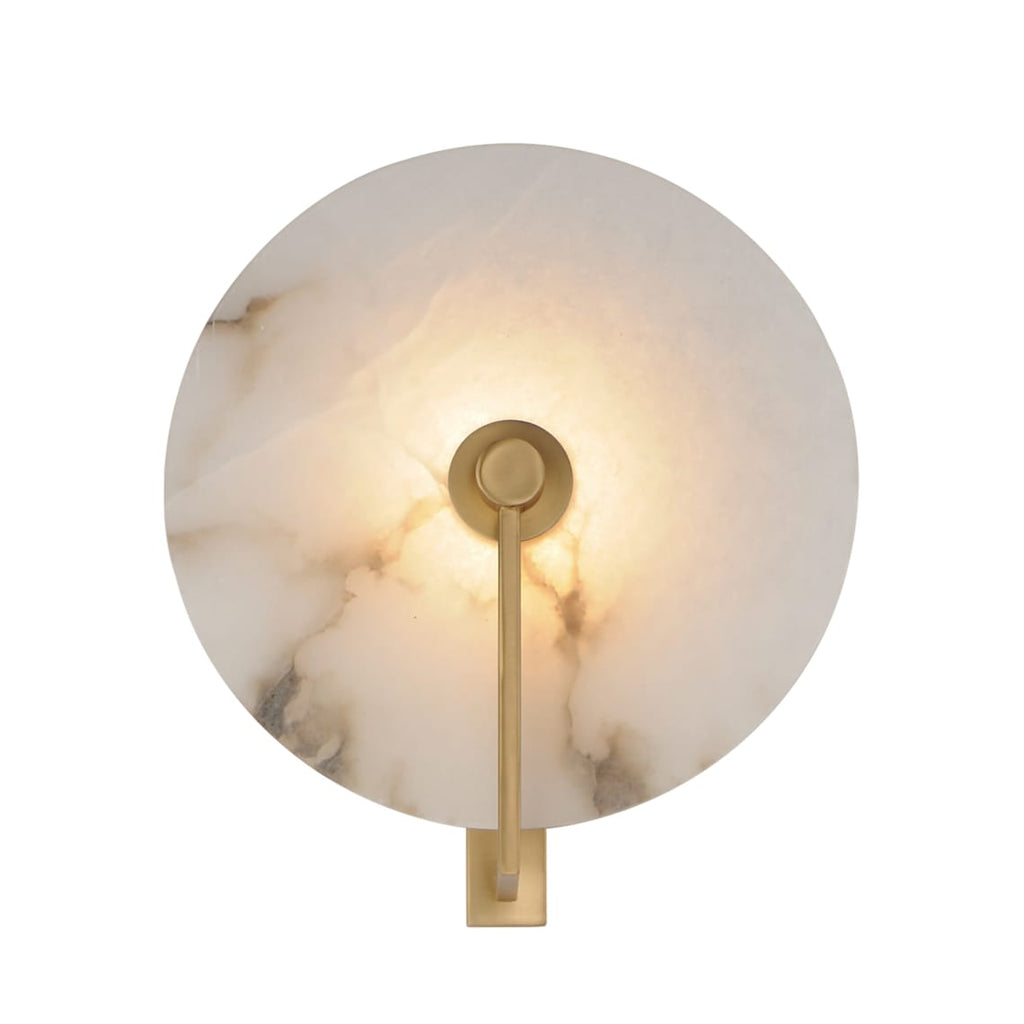 Front-facing studio shot of this Clérachic wall sconce in brushed brass, the disc glowing warm from within.