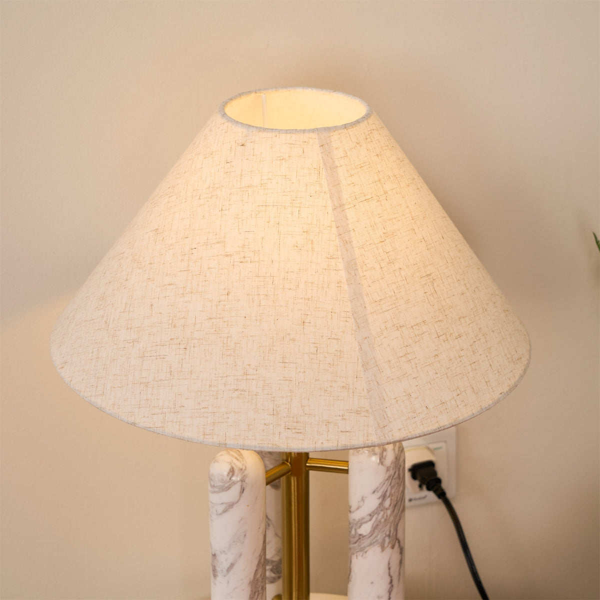 Looking up into the Clérachic lamp's cream shade, its open underside and brass pole visible from below.