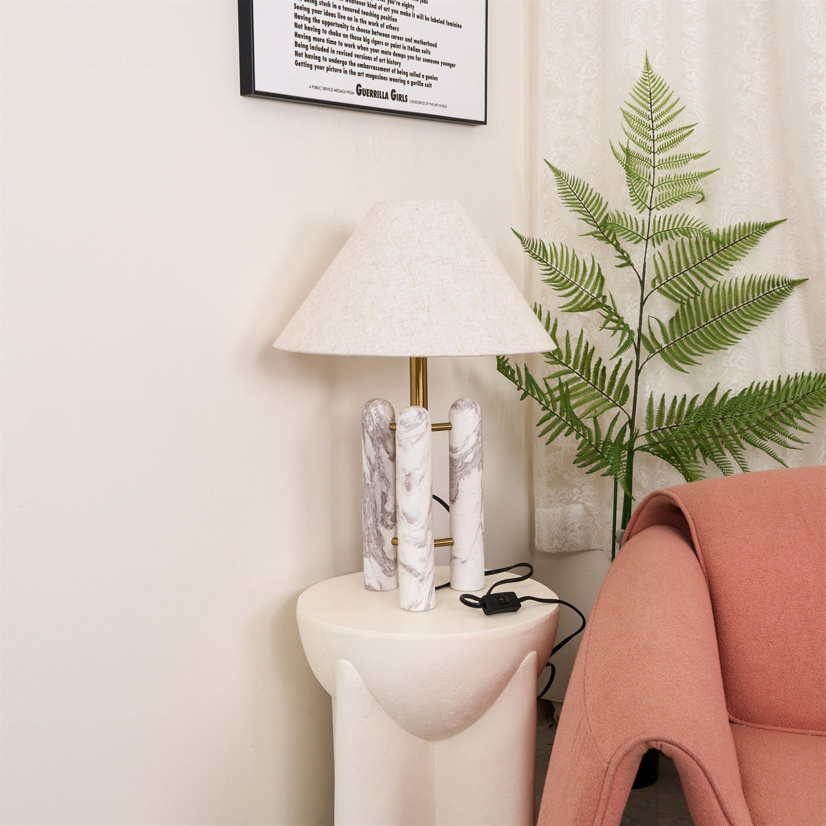 Closer crop of the Clérachic lamp's cord and switch by a wall socket, the coral armchair's arm just entering the frame.