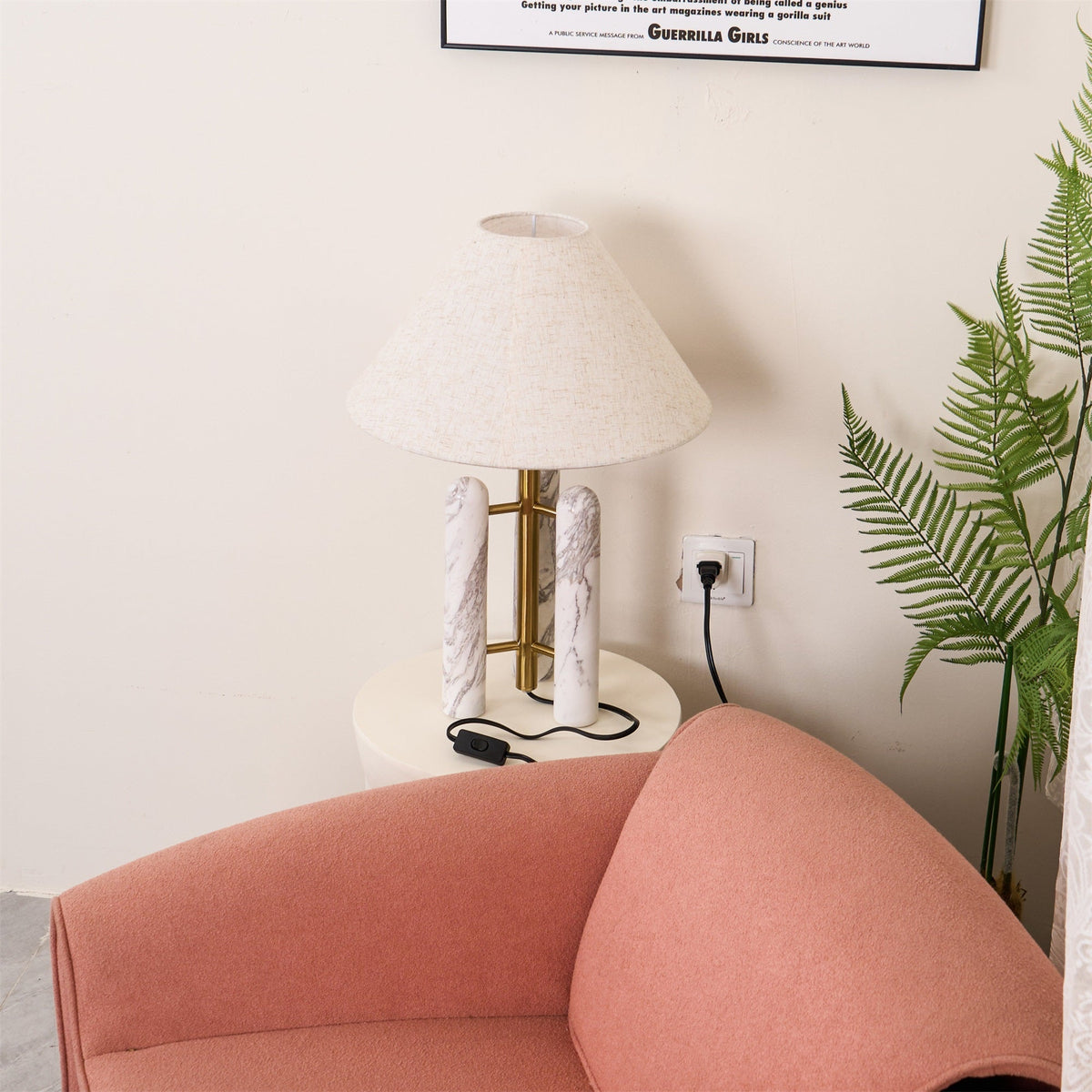 Tight crop of the room corner: mostly the coral armchair and a wall socket, with only the Clérachic lamp's shade edge in view.