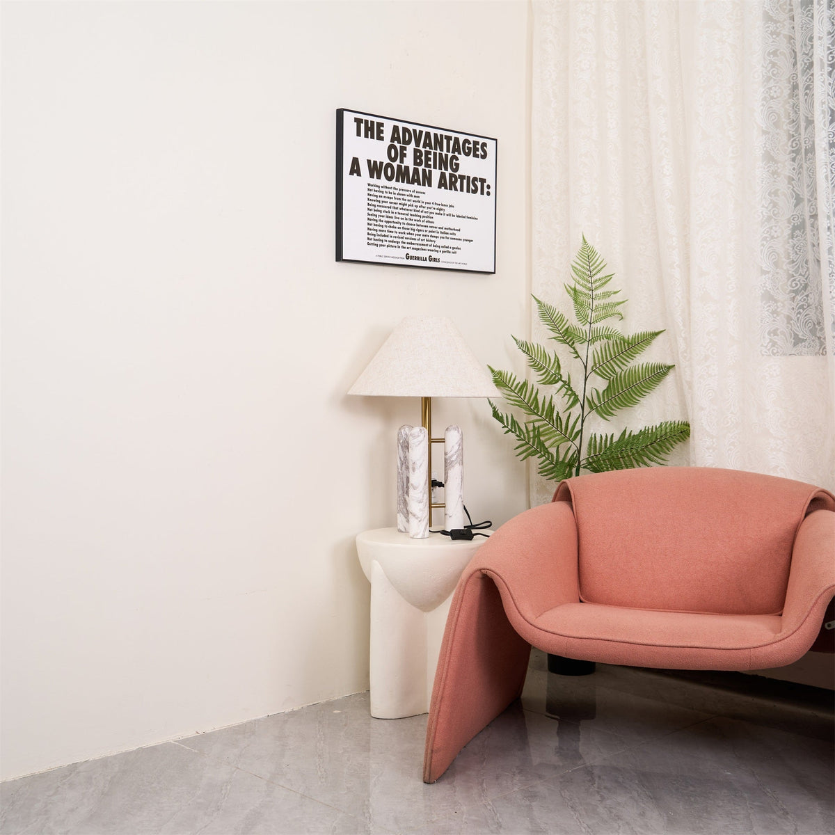 Wider shot of the same corner: Clérachic table lamp, framed print and fern, with the armchair reduced to a sliver at the edge.