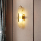 Clérachic veined alabaster Olraeia sconce lit on a fabric-panelled wall beside a tied-back grey curtain