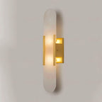 Clérachic narrow brass Olraeia sconce seen from the right, brass bars catching the light along the stone edge