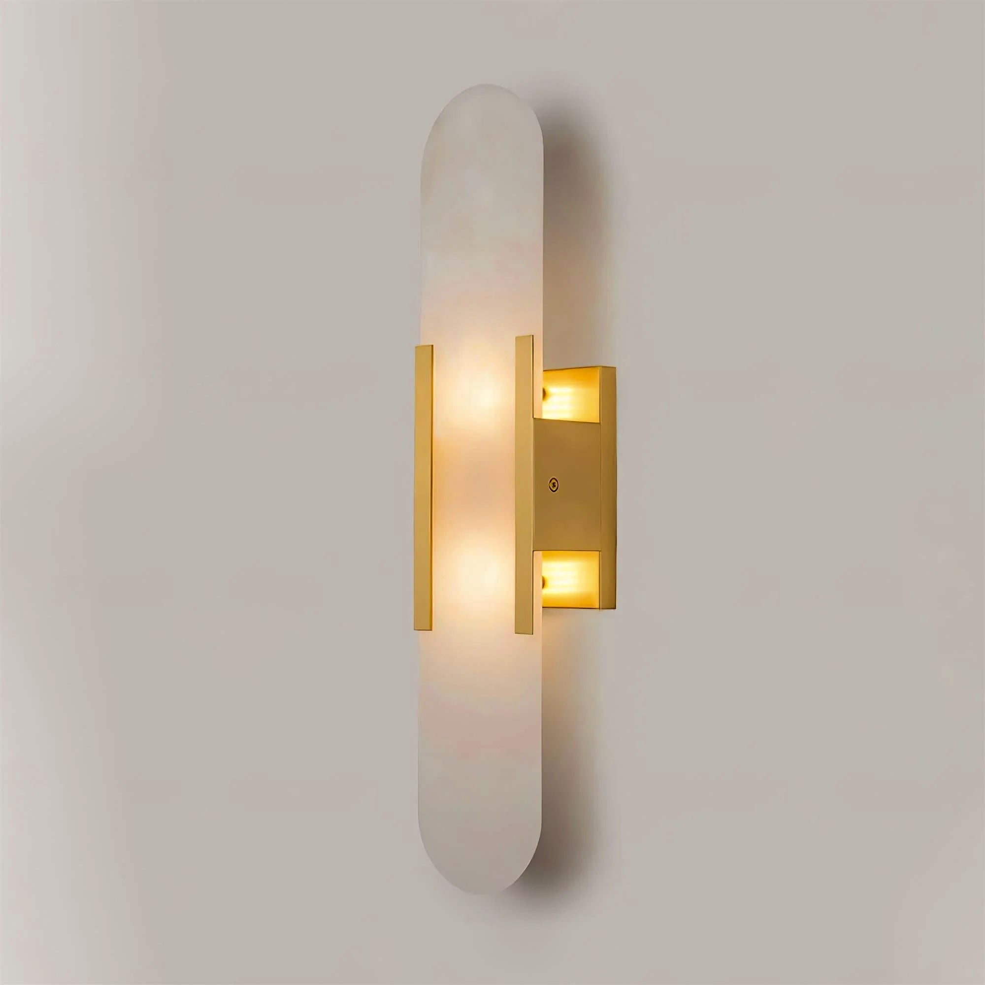 Clérachic narrow brass Olraeia sconce seen from the right, brass bars catching the light along the stone edge