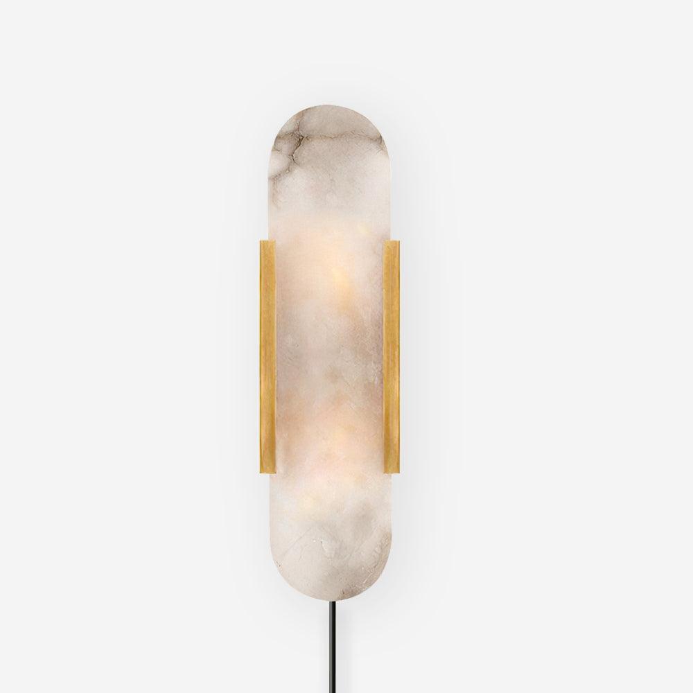 Brass Kristy alabaster sconce lit on white, heavy natural veining running through the stone