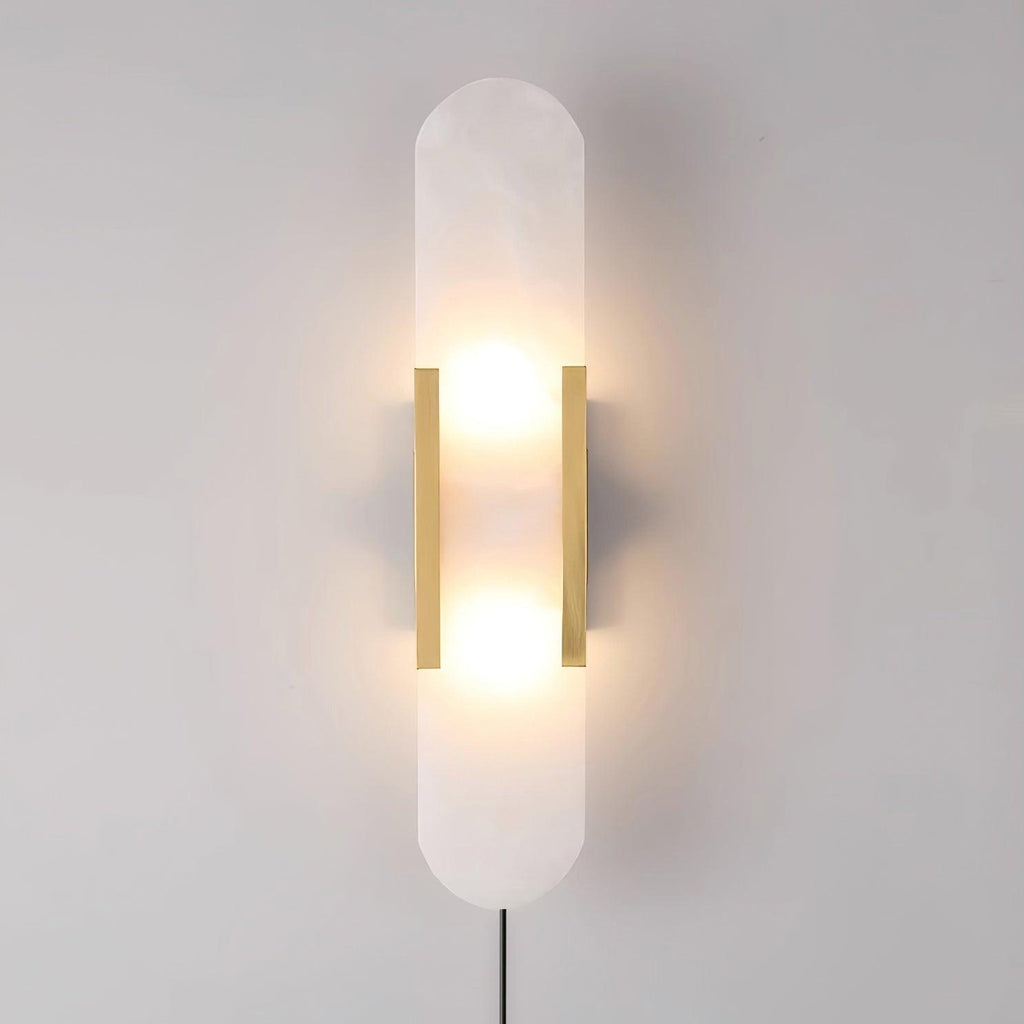 Brass Kristy alabaster wall lamp lit almost square on, two bulb glows visible through the stone