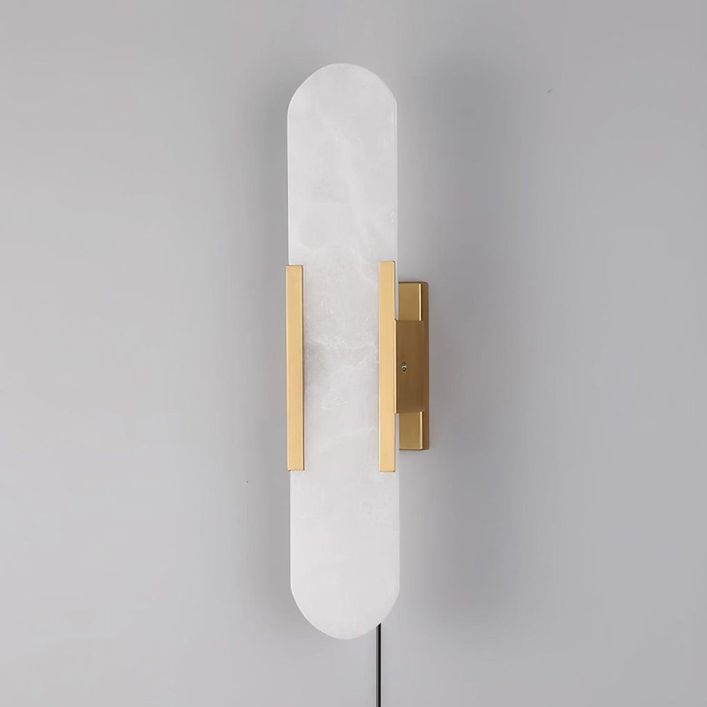 Unlit brass Kristy alabaster sconce angled right, its plug-in cord hanging from the base