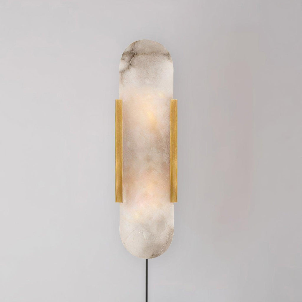 Brass Kristy sconce on a grey wall, the grey-brown veining of the natural alabaster clearly visible