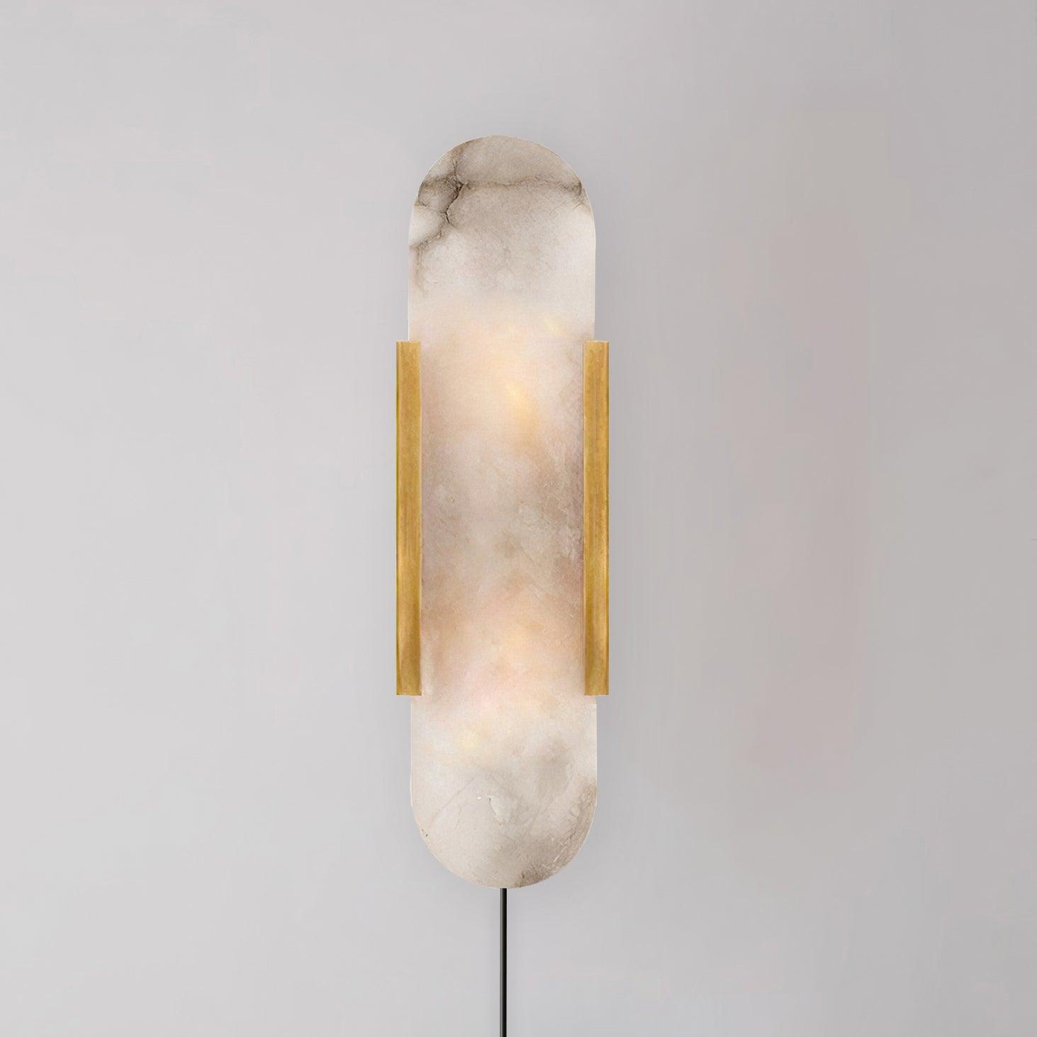 Brass Kristy sconce on a grey wall, the grey-brown veining of the natural alabaster clearly visible