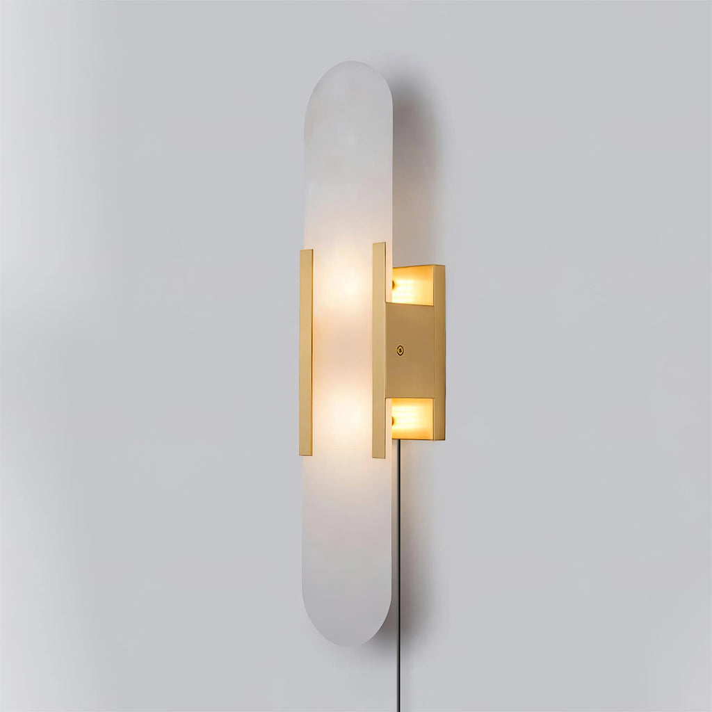 Three-quarter view of the brass Kristy sconce showing the depth of the wall bracket and the cord