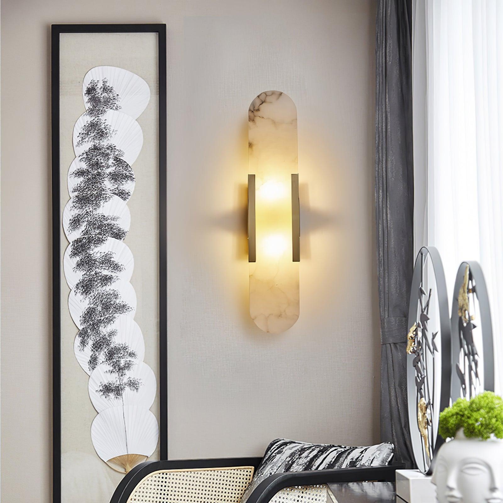 Clérachic heavily veined alabaster Olraeia sconce on a linen wall beside framed fan artwork and a rattan chair