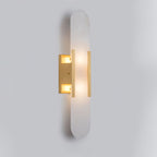 Clérachic slim brass Olraeia sconce angled left, both lamp compartments glowing behind the backplate