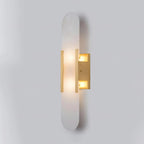 Clérachic slim brass Olraeia sconce angled right on grey, both bulb compartments lit inside the backplate