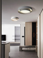 Cylinder ceiling light lit warm against the ceiling