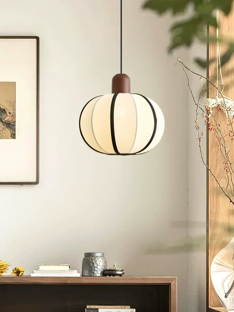 Above a console with sunflowers and framed art, this Clérachic pendant's cream fabric shade glows warm.